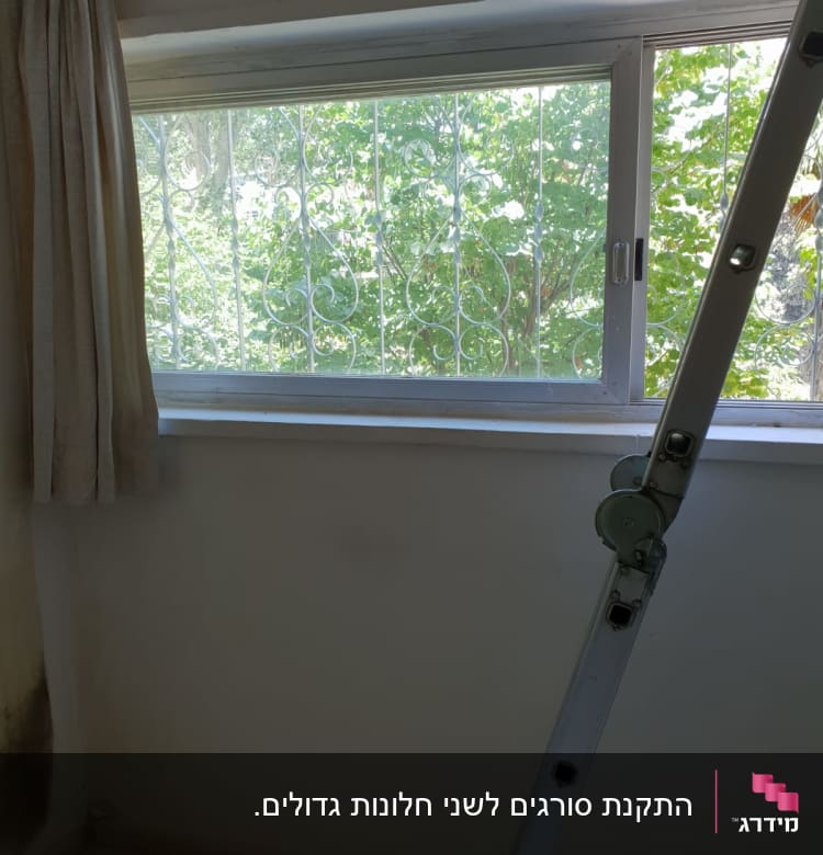 חלון עם מסגרת מתכת וסולם לידו